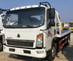 Flatbed towing wrecker truck rear view with auxiliary wheels and bandages