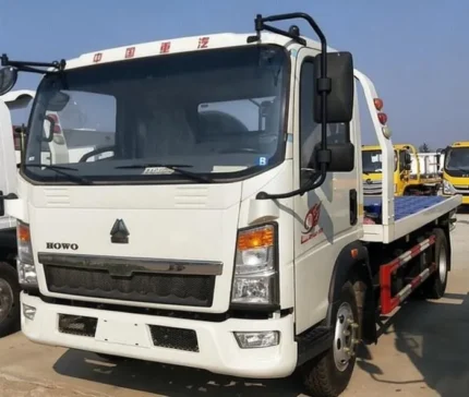 Flatbed towing wrecker truck rear view with auxiliary wheels and bandages