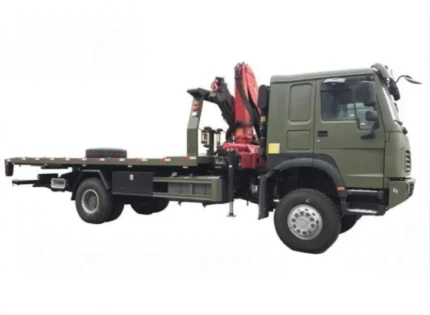 Yellow warning lamp and outriggers visible on flatbed towing truck