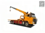 Hydraulic crane on flatbed recovery truck platform
