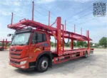 Dual-level hydraulic car transport platform loaded with vehicles