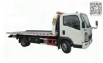 Hydraulic flatbed tow truck operating on inclined road
