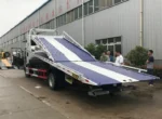 Flatbed tow truck carrying 3 cars