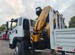 Rear flip-down outrigger legs on folding boom truck